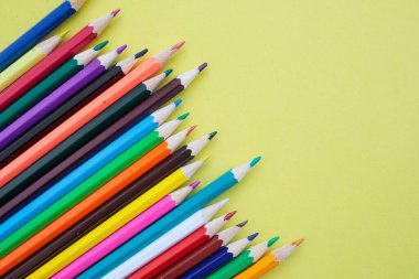 Sarı arka planda renkli kalemler. Yazıtlar için parlak, sulu bir arka plan. Yaz dönemi. - Okul. 1 Eylül. Ofis. Çalış.