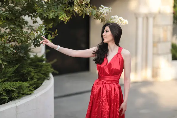 Yazın uzun siyah saçlı, kırmızı uzun elbiseli güzel bir genç kız.