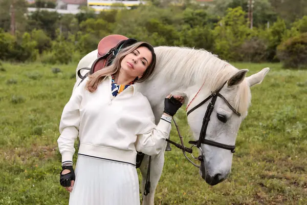 Tarlada beyaz atı olan güzel bir kız