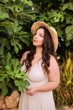  Yazın yeşil ağacın yanında şapkalı güzel bir kız.