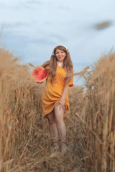 Yazın buğday tarlasında güzel bir genç kız ve karpuz