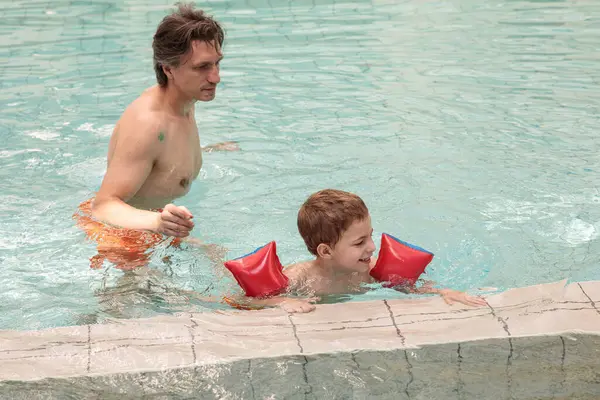 Mutlu baba ve oğul yazın havuzda