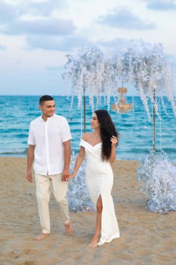 Gelin ve damat yazın sahilde. Düğün için. Aşk hikayesi. Açık havada düğün töreni.