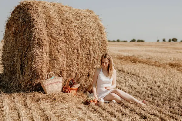 Yazın samanlıklarla dolu bir tarlada sarışın güzel bir kız.