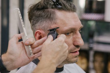 Berber dükkanı. İş yerinde erkek kuaförü. Berber iş başında. Kuaförde erkek tıraşı..