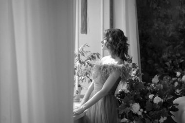 Kızıl saçlı, uzun gri elbiseli güzel bir kız.