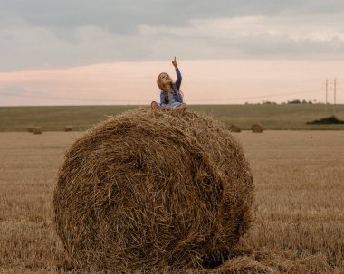 Yazın gün batımında samanlıkta sarı saçlı güzel bir kız..