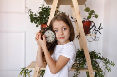 Bir kızın elinde çalar saat var.