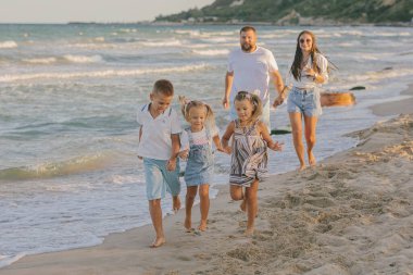 Büyük, güzel bir aile yazın sahilde.