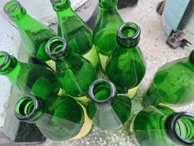 Boş yeşil bira şişesi yerde.