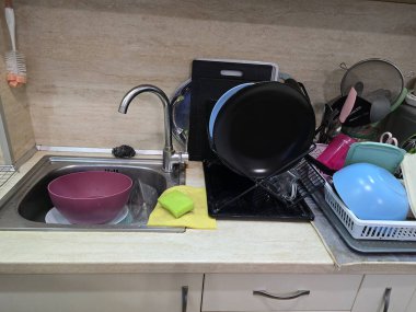 Mutfakta bulaşık yıkıyorum. Mutfaktaki lavaboda kirli bulaşıklar.