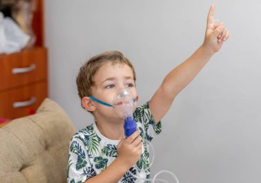 Küçük sarışın çocuk üç-dört yıl bir Nebulizatör ile tedavi edilir, öksürük. Küçük çocuk bir Nebulizatör kullanarak tedavi solunum yapar.