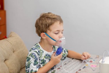 Küçük sarışın çocuk üç-dört yıl bir Nebulizatör ile tedavi edilir, öksürük. Küçük çocuk bir Nebulizatör kullanarak tedavi solunum yapar.