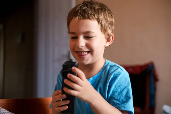 Mutlu küçük çocuk evde oyuncaklarla oynuyor.