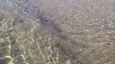 Güneş ışığı kristalde kırılmıştır, henüz tamamen uyanmamıştır. Parlak çok boyutlu yansımalar dans ederek suyun en dibine kadar uzanan ışıltılı bir dantel oluşturur. Aydınlanmış, saf dalgalar sessiz kumlu sahili okşuyor..