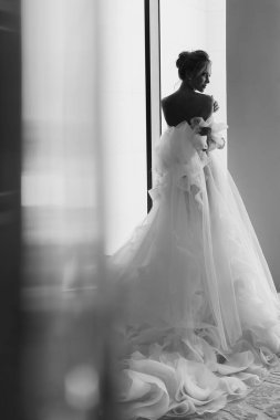 Pencerede poz veren güzel gelin. düğün fotoğrafı