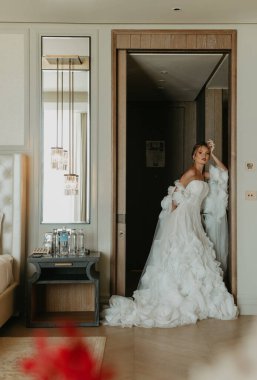 Lüks otel odasında poz veren gelinlik içindeki güzel gelin.