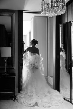 Gelinlik giymiş gelin siyah beyaz arkadan çekim yapıyor.