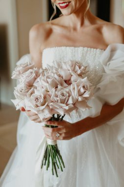 Gelin elinde gül buketi tutuyor