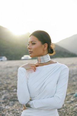 Çölde poz veren beyaz elbiseli güzel bir esmer.