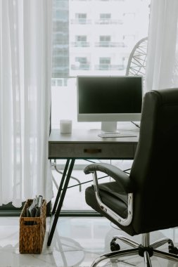 Koyu kahverengi sandalyeli modern çalışma alanı ve beyaz bilgisayarlı ahşap gri masa. 