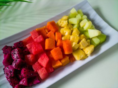 Dikdörtgen beyaz tabakta taze meyve salatası