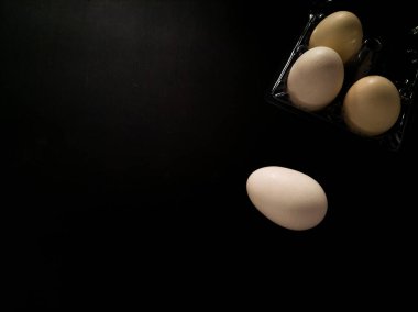 Koyu yüzeyde yumurtalar ve siyah arkaplan