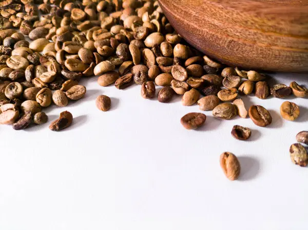 beyaz masa üzerinde kavrulmuş kahve çekirdekleri