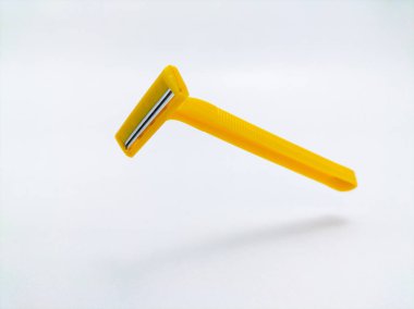 Beyaz arkaplanda sarı tek kullanımlık tıraş bıçağı