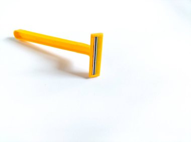 Beyaz arkaplanda sarı tek kullanımlık tıraş bıçağı