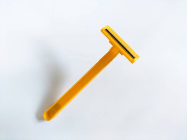 Beyaz arkaplanda sarı tek kullanımlık tıraş bıçağı