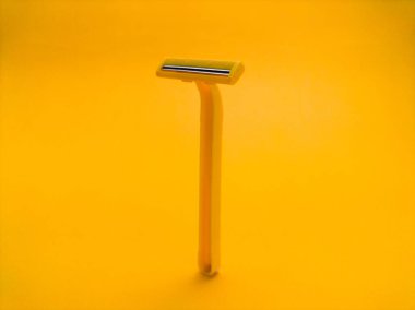 Sarı arka planda tek kullanımlık sarı tıraş bıçağı