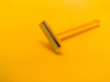 Sarı arka planda tek kullanımlık sarı tıraş bıçağı