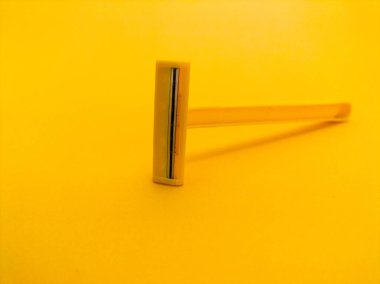 Sarı arka planda tek kullanımlık sarı tıraş bıçağı