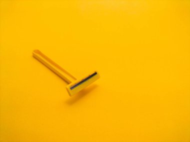 Sarı arka planda tek kullanımlık sarı tıraş bıçağı