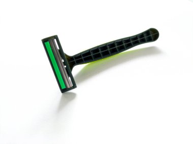 Beyaz arkaplanda yeşil tek kullanımlık tıraş bıçağı