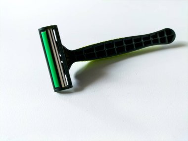 Beyaz arkaplanda yeşil tek kullanımlık tıraş bıçağı