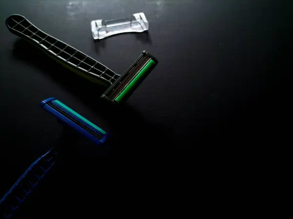 Siyah arkaplanda plastik tek kullanımlık tıraş bıçağı
