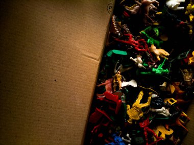 Karton bir kutuda renkli plastik oyuncaklar