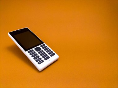 Kahverengi kağıttan arka planda eski bir cep telefonu