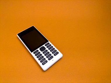 Kahverengi kağıttan arka planda eski bir cep telefonu