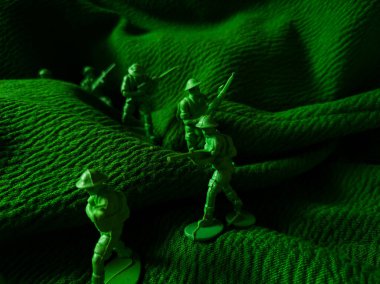 Yeşil kumaş arka planında yeşil plastik ordu oyuncağı