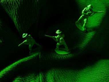 Yeşil kumaş arka planında yeşil plastik ordu oyuncağı