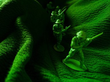 Yeşil kumaş arka planında yeşil plastik ordu oyuncağı