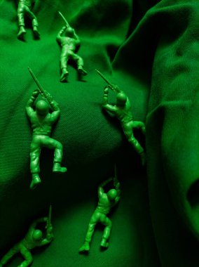 Yeşil kumaş arka planında yeşil plastik ordu oyuncağı