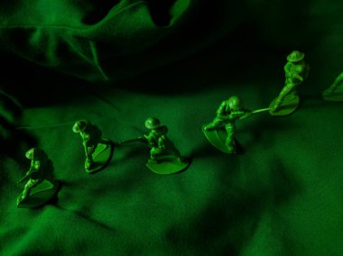 Yeşil kumaş arka planında yeşil plastik ordu oyuncağı