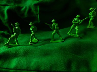 Yeşil kumaş arka planında yeşil plastik ordu oyuncağı
