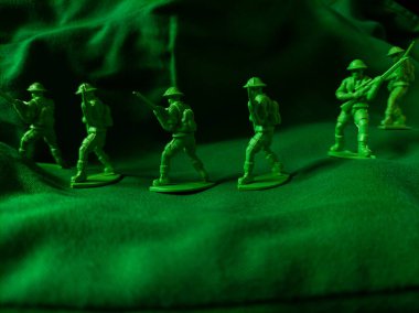 Yeşil kumaş arka planında yeşil plastik ordu oyuncağı