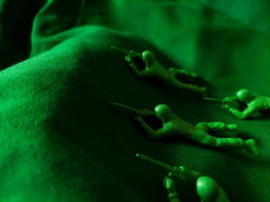 Yeşil kumaş arka planında yeşil plastik ordu oyuncağı