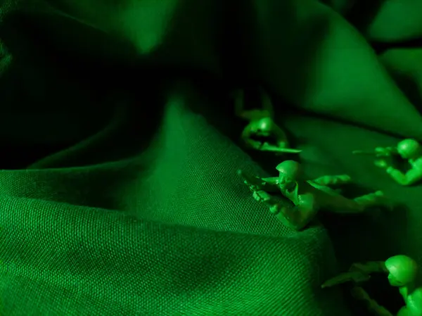 Yeşil kumaş arka planında yeşil plastik ordu oyuncağı